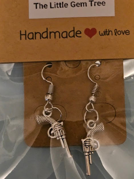 Pair of gun-shaped earrings on a 'The Little Gem Tree' branded card.