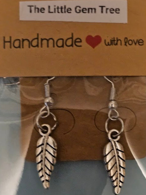 Silver leaf-shaped earrings on a 'The Little Gem Tree' branded card.