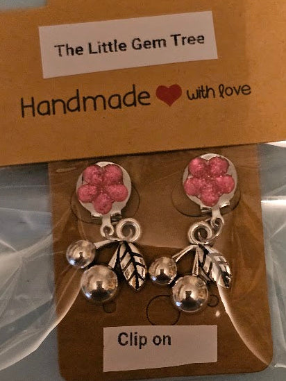 Pair of clip-on earrings with pink gemstones and silver accents on a 'The Little Gem Tree' branded card.