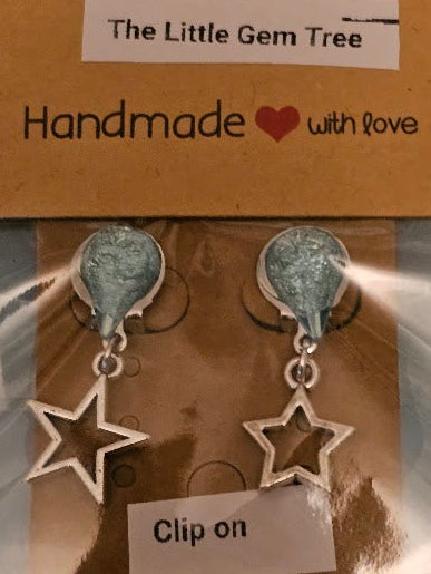 Star-shaped earrings on a 'The Little Gem Tree' branded card with a gray background
