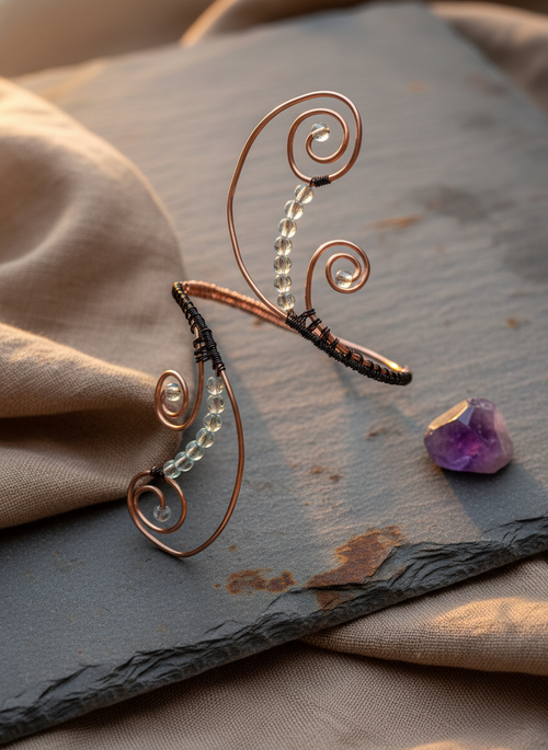 Copper and black wire beaded arm band on natural surface